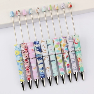 Set of 10 patterned plastic beaded pens featuring floral and leopard prints on white background