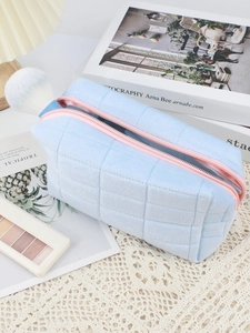 Quilted velvet makeup bag detail showing interior storage capacity with makeup brushes