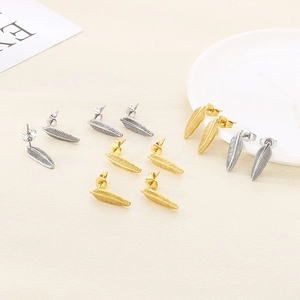 Minimalist feather earrings in gold and silver finish with detailed brushed metal texture