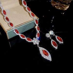 Macro shot of silver luxury jewelry set with red oval stones and sparkling crystals