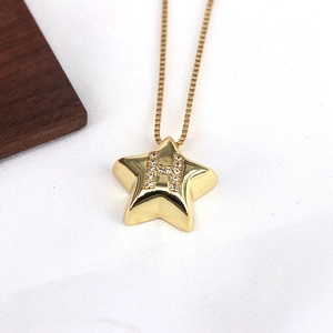 Close-up of a gold star pendant featuring a zircon-encrusted letter H on a snake chain