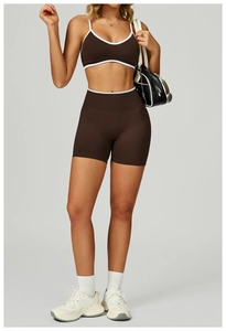 Detail von dunkelbraunem geripptem Yoga-BH mit weißer Paspelierung und hoher Taillenhose