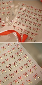 Macro shot of M1362 red bow nail stickers with gold stars and bells for festive manicures