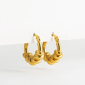 Macro detail of gold twisted rope hoop earrings with high mirror-like polished finish