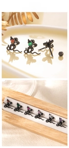 Macro detail of snake-shaped titanium steel ear studs with colorful pear-cut zircons