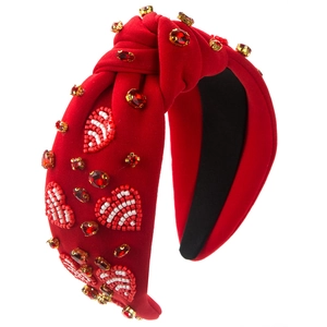 Detail of red knotted headband with beaded heart patterns and shiny red rhinestones