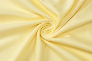 Gros plan du tissu en maille jaune pâle montrant la texture et le tissage doux