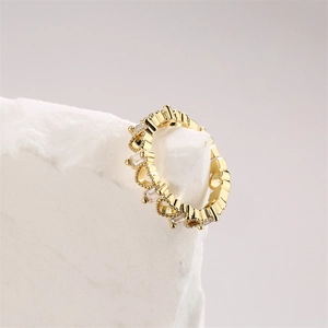 Gros plan d'une bague coeur dorée avec zircons baguette sur une pierre minérale