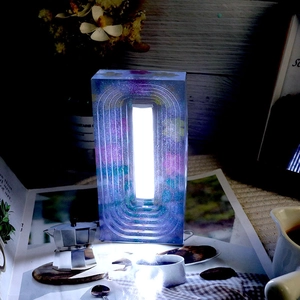 Arch-shaped resin night light with dried flowers and LED light on a magazine