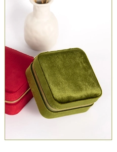 Detalle macro de joyeros de terciopelo rojo y verde oliva con elegantes cremalleras doradas