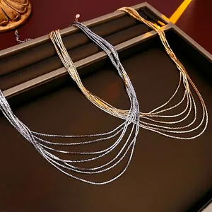 Minimalist multi-layer gold and silver plated snake chain necklace in jewelry display tray