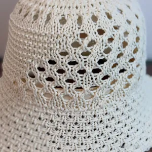 Close-up detail of white hollow woven bucket hat showing intricate crochet knit patterns