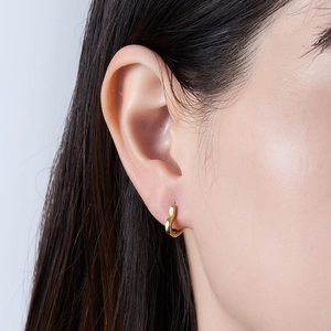 Minimalist gold heart hoop earrings for women shown on a model in a side profile view