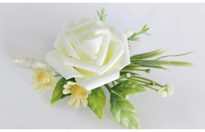 Detail of white artificial rose boutonniere with yellow wildflowers and ribbon wrap