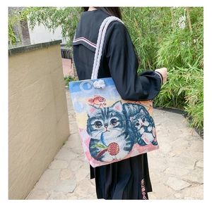Detailed view of large canvas tote bag with cat illustration and thick cotton rope handles