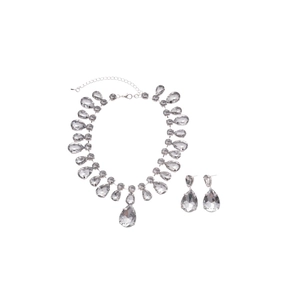 Sparkling silver necklace and earrings set with teardrop crystals on white background