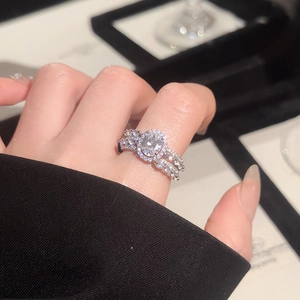 Detail of elegant silver oval ring with pavé zircons on woman's finger with black outfit