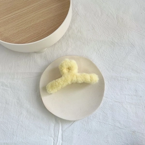 Große gelbe Plüsch-Haarklammer aus weichem Kunstfell für Damen auf einem weißen Hintergrund