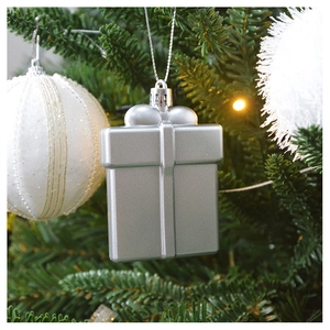 Detailed close-up of a silver gift box ornament hanging on a festive Christmas tree