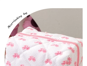Détail du tissu matelassé avec motifs nœuds roses et fermeture à glissière résistante