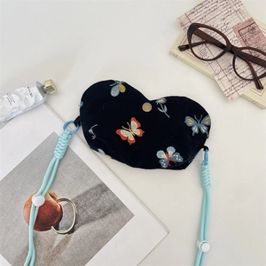 Détail du sac cœur en velours brodé de papillons avec bandoulière tressée bleue