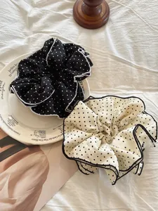 Detail of black and white polka dot tiered scrunchies with refined hemmed edges