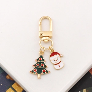 Christmas tree and snowman metal keychain with gold clasp on white background