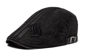 Detail of black cotton ivy cap with gothic 'B' embroidery and silver metal buckle