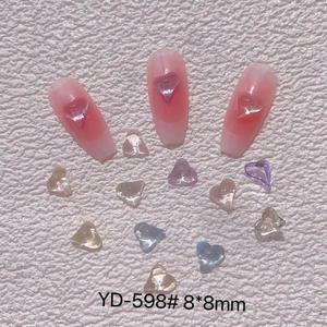 Macro detail of transparent 3D heart nail charms in mixed colors for manicure art