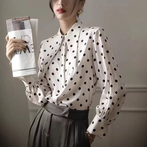 Detailed view of polka dot satin blouse with oversized pointed collar and pleated cuffs