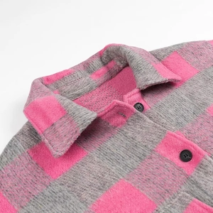 Detailed view of pink and grey plaid fabric with lapel collar and black button closure