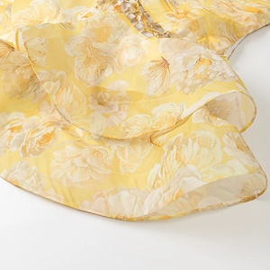 Close-up of yellow floral chiffon dress with butterfly prints and metal chain detail
