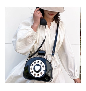 Detail of retro telephone crossbody bag with heart dial and glossy black finish