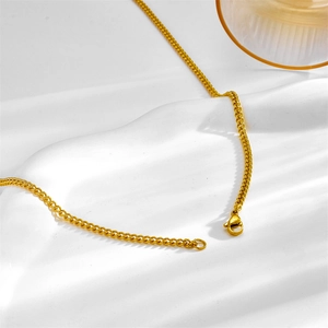 Polished gold cuban link titanium steel necklace with lobster clasp on white background