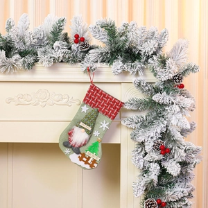 Detail of Christmas stocking featuring a faceless gnome doll and festive pine cone garland