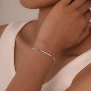 Macro shot of minimalist silver flat snake chain bracelet on skin for elegant look