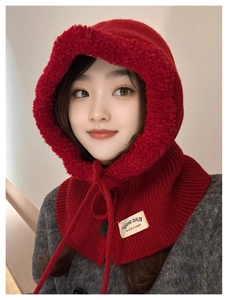 Close-up of deep red knitted balaclava showing soft faux fur lining and black buttons