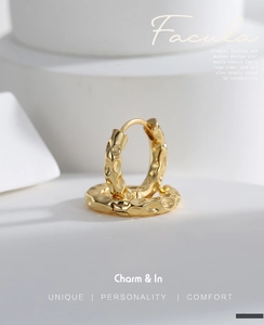 Detail of gold-plated brass hoop earrings with unique hammered textured finish