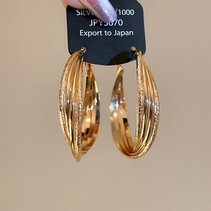 Vue détaillée des boucles d'oreilles plaquées or 18 carats avec anneaux croisés mats