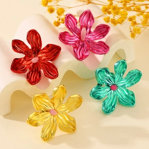 Macro shot of oversized hollow flower rings in red, pink, yellow, and green metal finishes