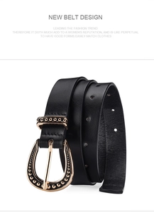 Detail of black leather belt featuring a vintage gold horseshoe buckle with beaded edges