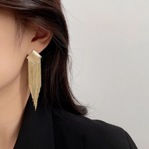 Golden square tassel drop earrings with brushed metal finish shown on a female model
