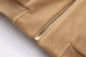Detailed macro shot of premium camel wool fabric texture and sturdy metal zipper closure