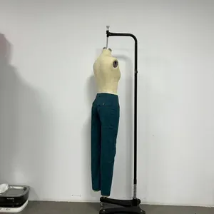 Detail of dark green high-waisted wide-leg trousers showing the back pocket with flap