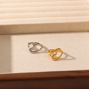 Macro detail of 18K gold and silver plated open heart rings in a wooden jewelry box