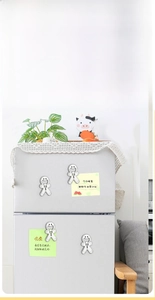 Detailed view of 4-piece silver metal gingerbread man bottle opener fridge magnets on a door
