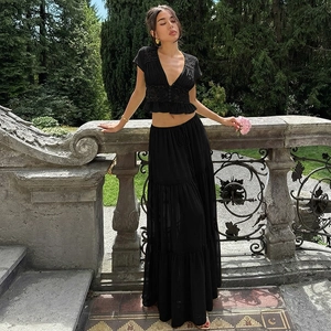Détail d'un ensemble deux pièces noir avec haut court en dentelle et jupe longue fluide
