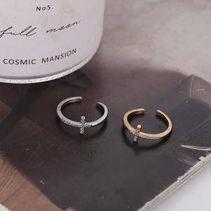 Elegant gold and silver cross rings with cubic zirconia inlay on vintage magazine