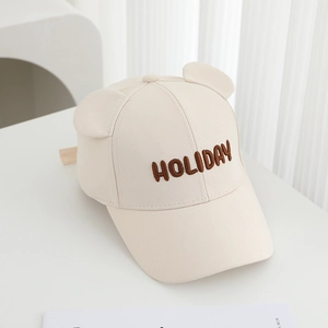 Close-up of beige cotton baseball cap with HOLIDAY embroidery and cute bear ears detail