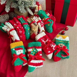 Detail of Christmas coral fleece socks with festive patterns and silk bow gift packaging